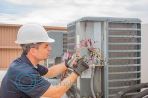 HVAC tech wiring a dual run capacitor on a air conditioner condensing unit