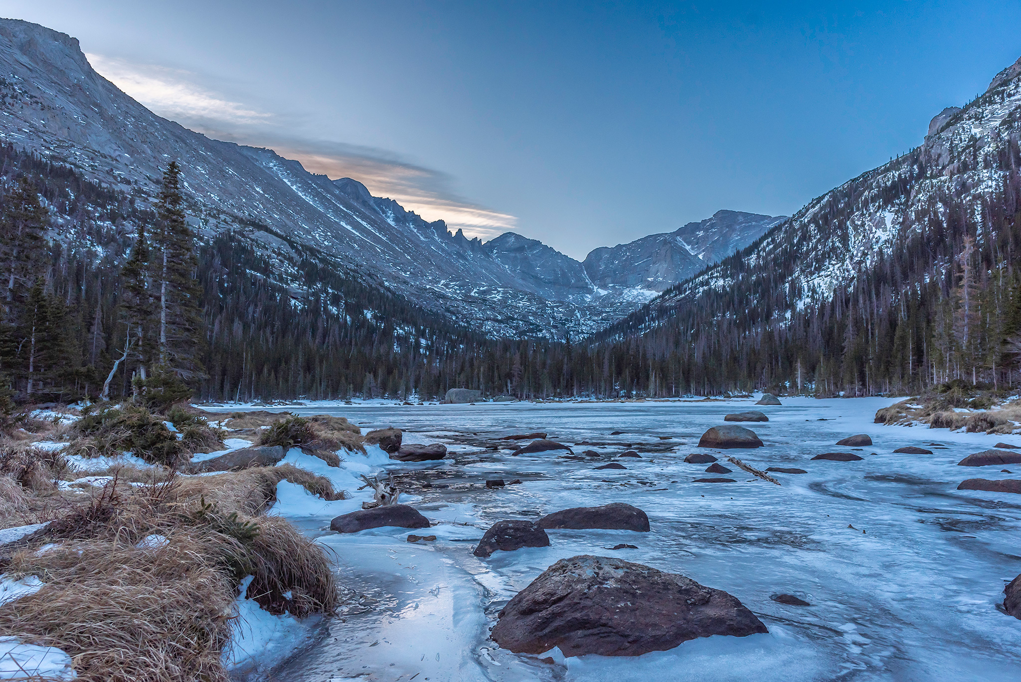 Jewel Lake with Henrys Peak in the background, frozen alpine lake in early Winter, Rocky Mountain National Park, Colorado, stream view