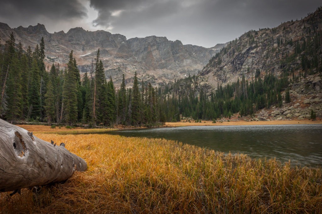 grassy shore of fourth lake and continental divide mountain range colorado