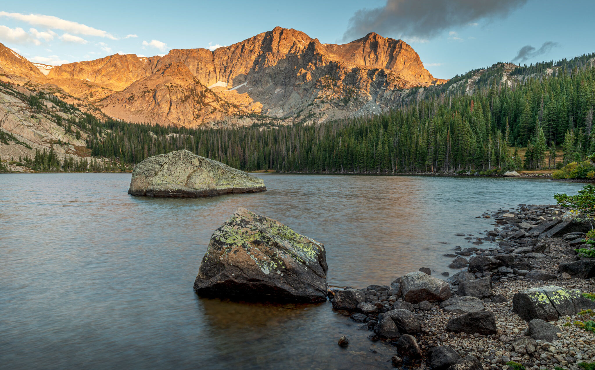 Sunrise at Thunder Lake, from the shore, rocks, lake surrounded by trees, Mt Alice in the background
