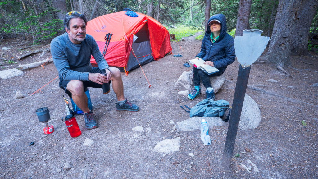 dave and emily at the thunder lake stock camp site with tent set up and bear canister
